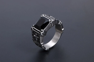 Macro shot of gothic cross ring with a large rectangular black faceted gemstone