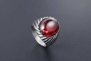 Detail of vintage titanium steel ring with large oval red agate and textured metal band