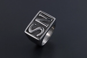 Macro view of rectangular signet ring for men featuring embossed letters and silver finish