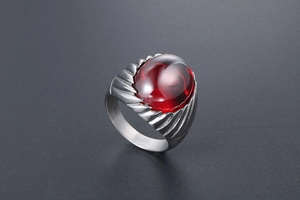Macro detail of men's vintage titanium steel ring featuring an oval red stone inlay