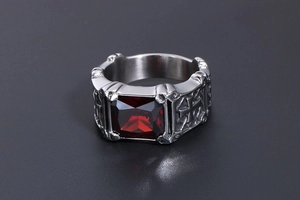 Detailed view of square red gemstone and gothic cross engraving on the silver ring