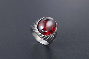 Close-up of retro men's steel ring featuring a large oval red agate and wing texture
