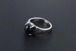 Detail of vintage flower embossed stainless steel ring with oval blue sandstone