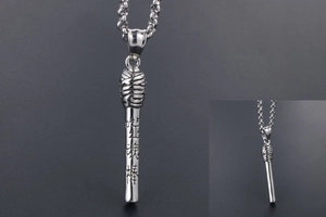 Detailed close-up of a silver stainless steel pendant with engraved Chinese characters