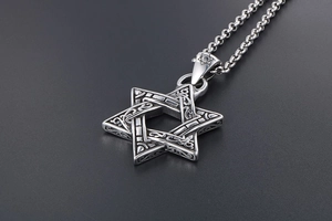 Macro shot of vintage silver hexagram pendant with intricate celtic knot patterns