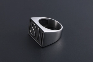 Detailed macro view of men's square signet ring with SN letter engraving in steel