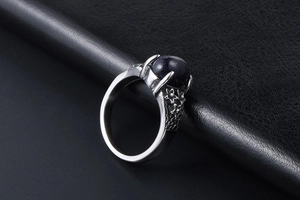 Macro shot of vintage ring featuring blue goldstone and floral engraved silver band