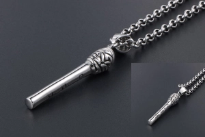 Close-up of a silver microphone pendant with spiral texture and artistic engraving
