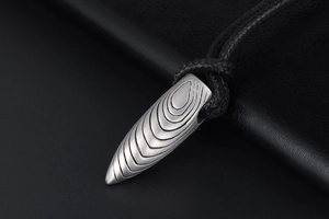 Détail d'un pendentif balle argent mat avec gravures de contour sur cuir noir texturé