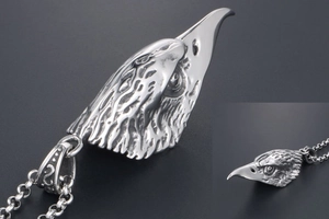 Detailed close-up of a realistic eagle head pendant made of polished stainless steel