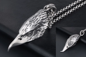 Detailed view of carved eagle head pendant with realistic feather textures on steel chain