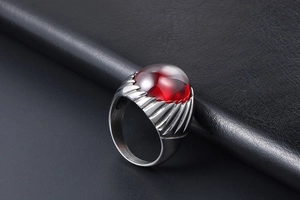 Detail of vintage men's steel ring with large oval red stone and ribbed textured sides