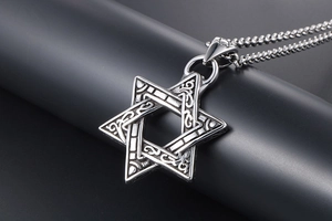 Detailed close-up of retro stainless steel hexagram pendant with intricate scroll engraving