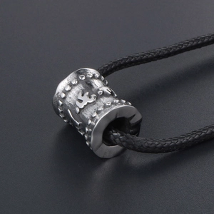 Pendentif cylindre mantra en acier titane rétro avec symboles sur un cordon noir