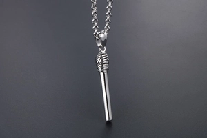 Macro shot of silver matchstick pendant with detailed head texture and metal chain