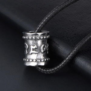 Pendentif cylindre rétro en acier titane avec mantra embossé sur un cordon noir
