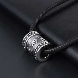 Titanium steel Buddhist Mantra cylinder pendant on black braided rope with vintage finish