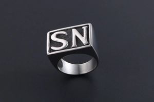 Close-up of a silver stainless steel signet ring featuring bold SN letter engraving