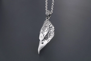 Detailed close-up of retro eagle head pendant in polished silver steel for men