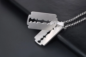 Detail of silver stainless steel razor blade pendant necklace on black leather texture