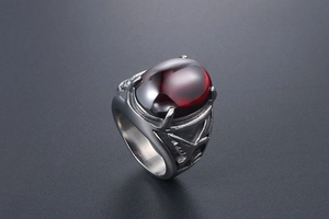 Close-up of vintage steel eagle ring with relief texture and red oval agate stone
