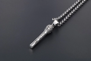 Macro shot of stainless steel cylinder pendant with engraved relief and link chain