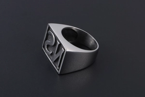 Macro shot of silver men's signet ring with brushed metal texture and 2M relief