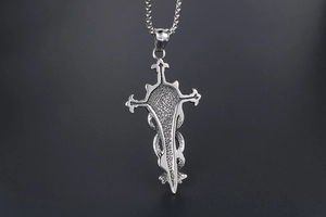 Detailed back view of a stainless steel sword and snake pendant with textured finish