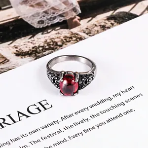 Vintage stainless steel ring with large oval ruby gemstone and floral filigree details