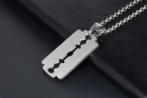 Macro view of stainless steel razor blade pendant with brushed texture on black leather