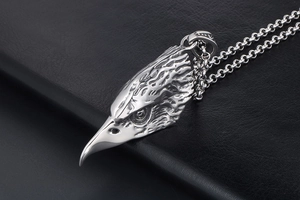 Macro shot of detailed eagle head pendant with oxidized silver finish and O-chain link