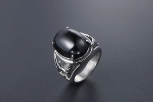 Macro detail of men's eagle relief steel ring featuring a polished black onyx stone