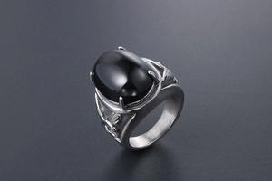 Macro shot of retro men's eagle ring with large oval black agate stone and leaf carvings