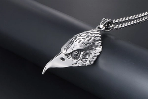 Detailed close-up of a vintage eagle head pendant with intricate feather texture and ball chain