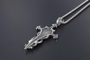 Macro shot of retro stainless steel cross sword pendant with detailed relief texture