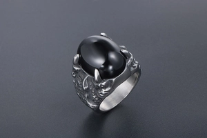 Gros plan d'une bague griffe de dragon gothique avec pierre noire ovale et écailles