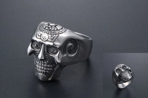 Detail of gothic silver skull ring with radial engraved patterns and vintage punk finish