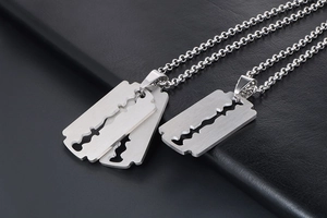 Detail of silver razor blade pendant with brushed metal texture on black leather