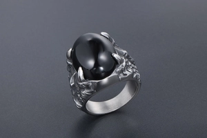 Détail de la bague punk rétro avec une grande pierre noire et une bande de griffe
