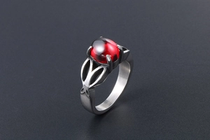 Macro side view of vintage stainless steel ring with large oval red gemstone and cutout detail