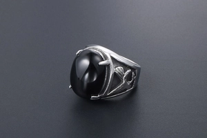 Macro shot of retro stainless steel eagle ring with black onyx and bird relief engraving
