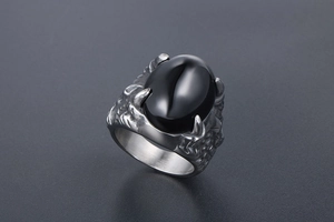 Détail d'une bague griffe de dragon gothique avec une grande pierre noire et finition rétro