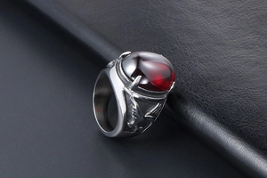 Macro shot of men's eagle relief ring with large oval deep red gemstone inlay
