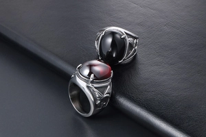 Detail of two-piece eagle rings featuring black and red inlaid stones in retro punk style