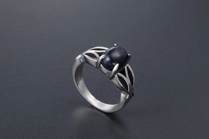 Detail of vintage stainless steel ring with blue sandstone and hollow leaf motifs
