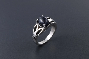 Detail of vintage stainless steel ring featuring oval blue sandstone and hollow patterns