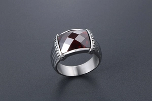 Vue macro d'une bague en acier avec pierre rouge carrée et détails striés pour hommes