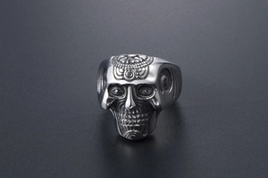 Detailed close-up of a silver gothic sugar skull ring with vintage floral engravings