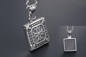 Detailed close-up of a vintage square pendant with 3D cross pattern and matte back