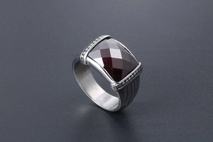 Détail d'une bague pour homme avec une grande pierre rouge rectangulaire et métal argenté